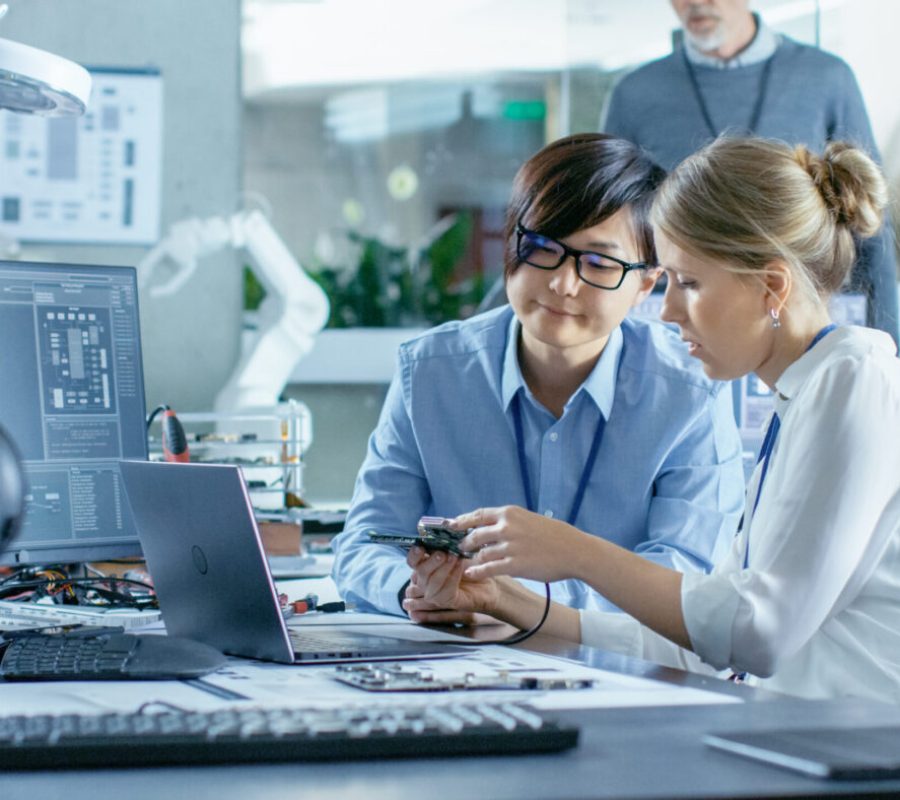 Asian Scientist Sitting at His Desk Consults Engineer They Conne